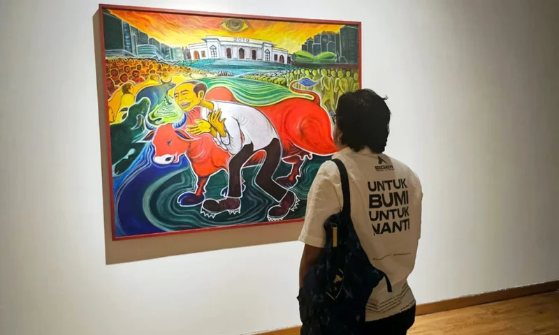 Seorang pengunjung sedang menyaksikan salah satu lukisan Yos Suprapto di Galeri Nasional Indonesia sebelum terjadinya pembatalan (Foto: X/@okkymadasari)