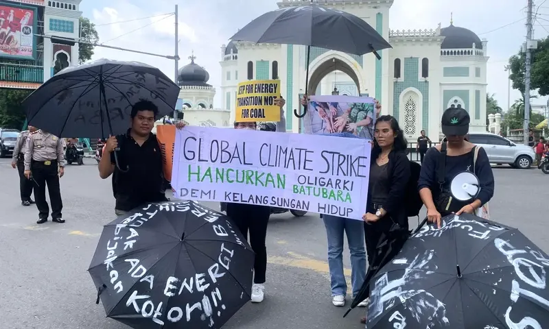 Aktivis lingkungan di Medan, Sumatra Utara menggelar aksi Global Climate Strike menyoroti kebijakan pemerintah yang masih menggunakan batu bara sebagai bahan bakar PLTU, di titik nol Kota Medan, Jalan Masjid Raya, Senin (18/9/2023). (Foto: PARBOABOA/Sonda
