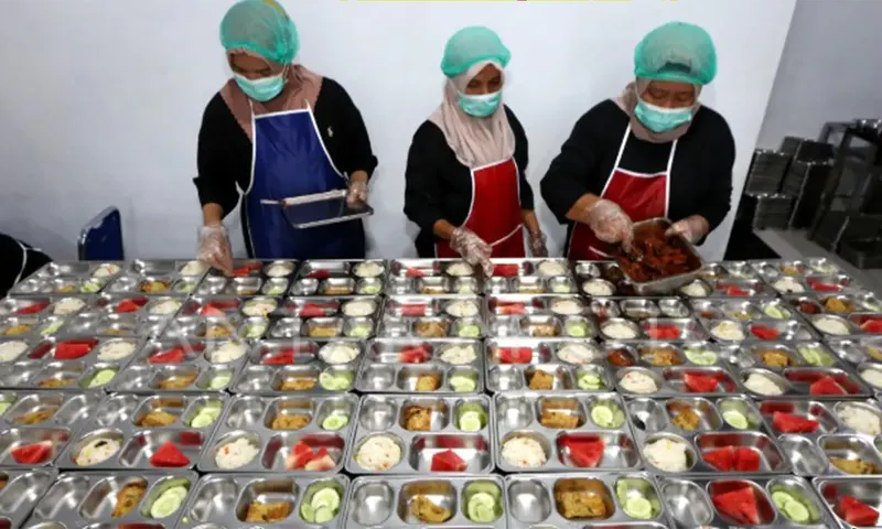 Petugas menyiapan makanan program Makan Bergizi Gratis (MBG) untuk didistribusikan kepada pelajar di Banda Aceh, Aceh, Jumat (16/5/2025)