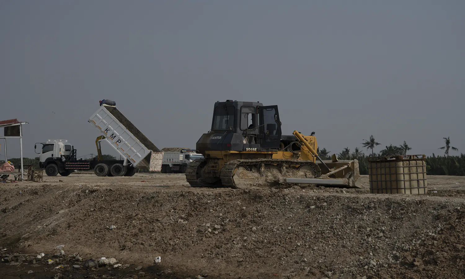 Alat Berat dan Truk Muatan untuk Pengurukan Lahan PIK 2 di Desa Kohod. (PARBOABOA/Patrick)