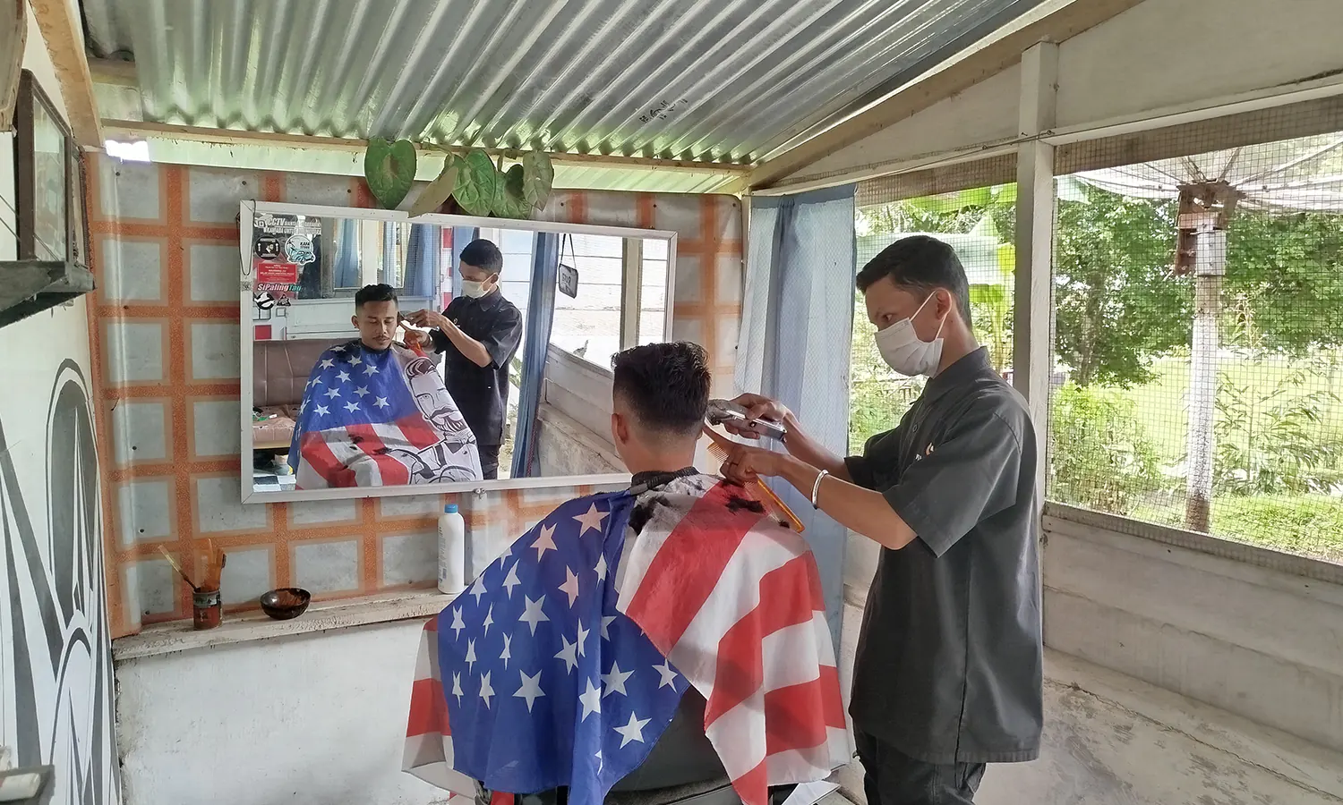 Ditengah tren mendaftar ASN di Simalungun, Nurul Kurniawan memilih menekuni profesi tukang cukur. (Foto: PARBOABOA/Pranoto)